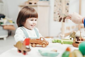 little girl plays with toys with parent