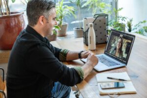 a man participates in online speech therapy from home