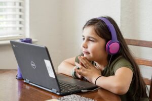 a young girl talks to her online speech therapist