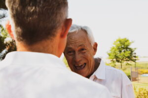 senior adult with aphasia smiles at his son